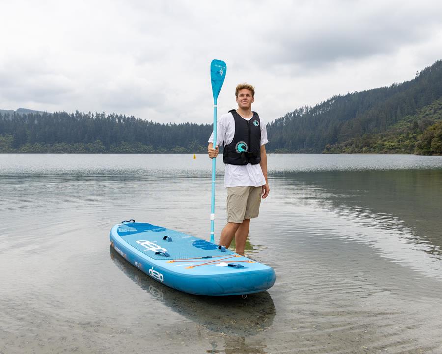 Person standing beside stand up paddle board